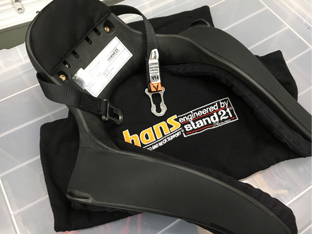 ▲これが頭部および頸椎の保護装置。Head And Neck Supportの頭文字をとってHANS（ハンス／ハンズ）と呼ばれる。首にU字の溝を通し、付属の金具でヘルメットに固定する
