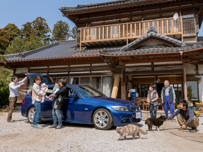 ▲立派な玄関の前にて「いらっしゃい！ よく来たね」の瞬間。車も家族の一員のようだ
