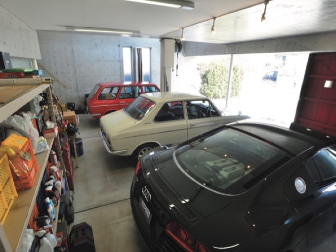 ▲壁側には膨大な量のケミカルグッズが並ぶ。田邉さんの愛車アウディ R8が、まるで自分の住み処であるかのように静かに佇んでいるのはご愛嬌